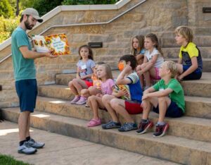 kids listening to story being read outside